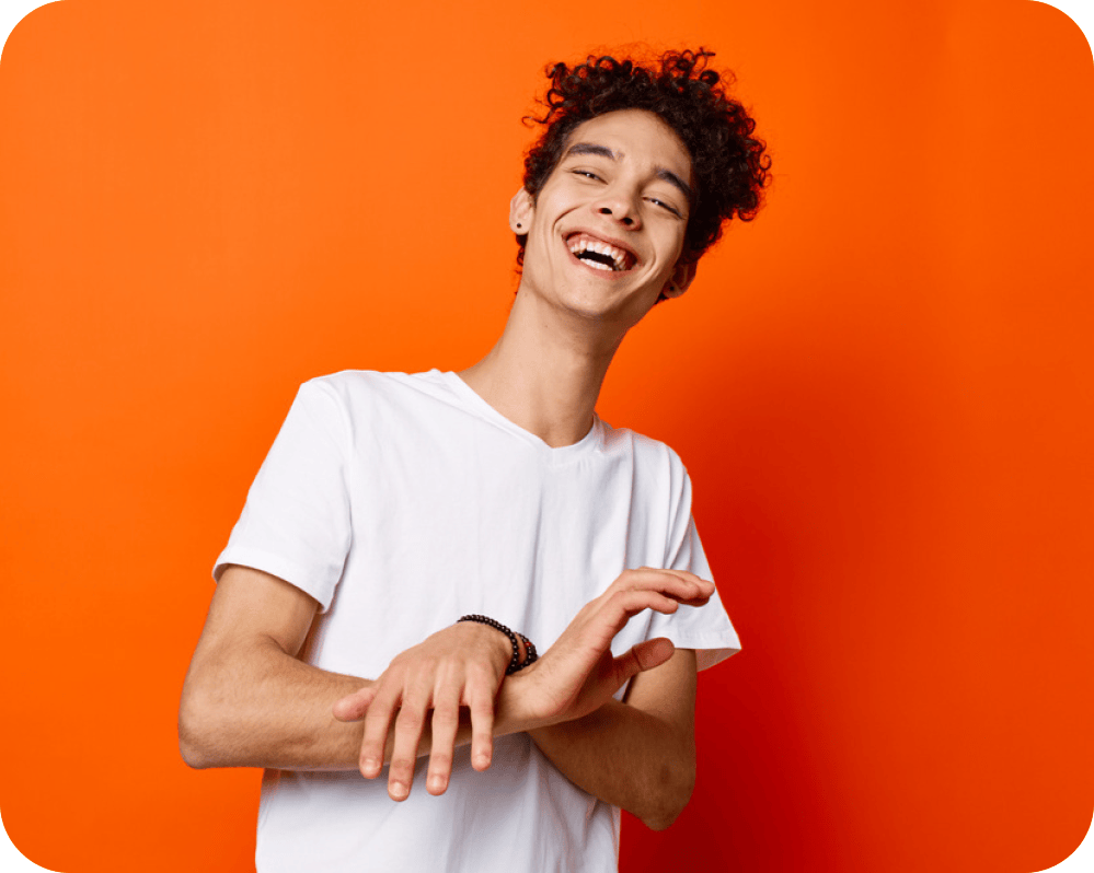 picture of a young man laughing. he is wearing a white T-shirt and is depicted on a red background